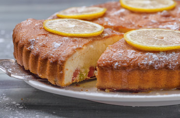 A piece of fresh homemade pie with slices of lemon on a vintage