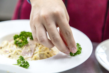 chef decorating meal in dish in the kitchen