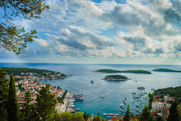 Tourists and wide angle aerial view of Hvar city and the bay from the Spanish fortress