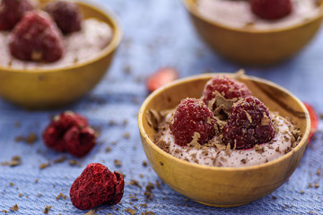 Raspberry dessert with chocolate in wooden bowls