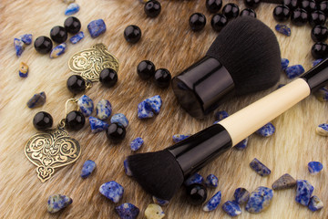 Makeup tools on Fur background / featuring eyeshadow palette, lipstick, makeup brushes on a fury background