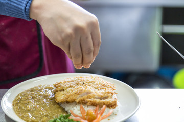 chef decorating meal in dish in the kitchen