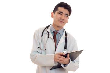 young male doctor in uniform with stathoscope looking away and smiling isolated on white background