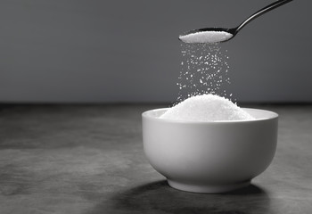 Sugar being poured from spoon into a bowl Empty ready for your p