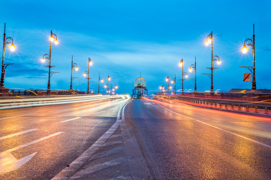 Old Town bridge "Staromiejski" with light trails and observation tower at sunrise.