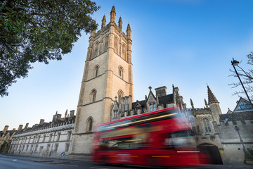 Fototapeta na wymiar Magdalen College, Oxford and blurry red double decker bus.