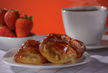 Apple strudel with coffee and strawberry on a red background