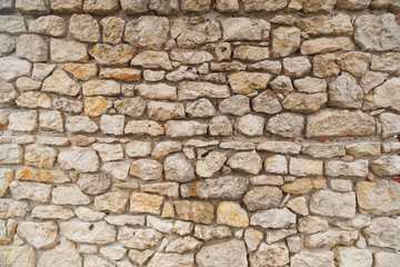 Texture of Medieval old light colored stone wall.