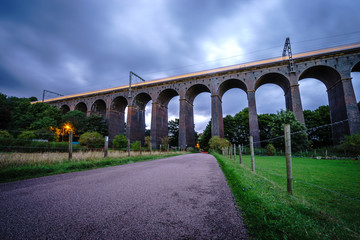 Fototapeta na wymiar Old railway viaduct with blue sky. Long exposure
