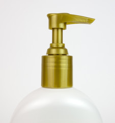 Fototapeta na wymiar Gold colored plastic bottle pump top. Isolated.