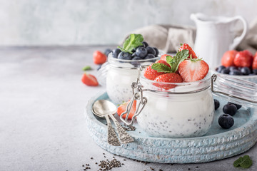 Chia seed pudding with berries in glass jar. Superfoods concept with copy space.