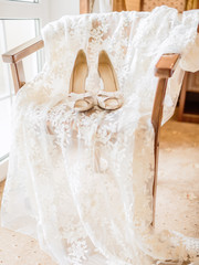 The bride's shoes and boudoir dress on a chair. Wedding.