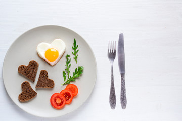 Fototapeta na wymiar Heart shaped eggs and bread. St. Valentine's Day breakfast