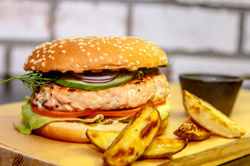 Burger with fish (salmon), cucumber and tomato.