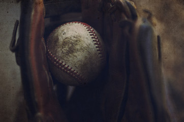 Old baseball caught in leather glove.  Sport or game background or print.