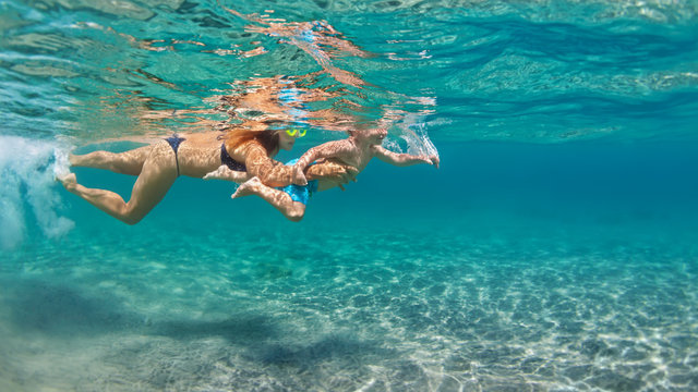 Happy family - mother with baby son dive underwater with fun in sea pool. Healthy lifestyle, active parent, people water sport outdoor adventure, swimming lessons on beach summer holidays with child - Powered by Adobe