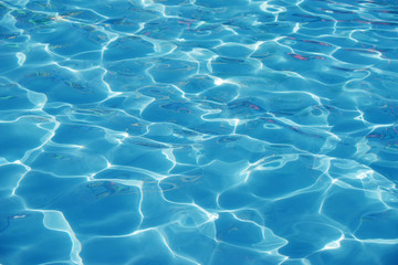 Fototapeta na wymiar Blue romantic rippling water surface with sun glare
