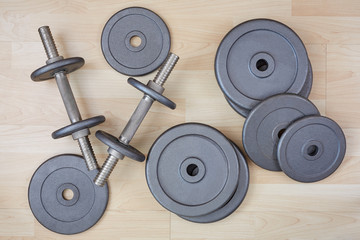 dumbbell and free weight on wooden floor