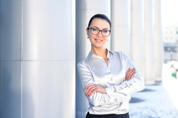 Young business woman in glasses and a white shirt. Successful businesswoman on the background of business centers