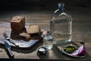 Fototapeta na wymiar vodka, vegetables and bread and salt on the table