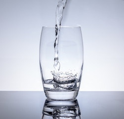 Wasser in Trinkglas einfüllen