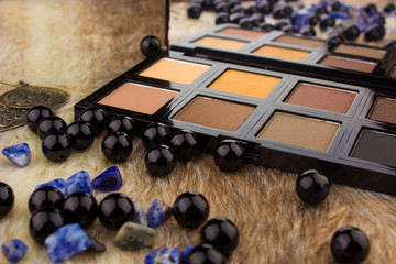 Makeup tools on Fur background / featuring eyeshadow palette, lipstick, makeup brushes on a fury background