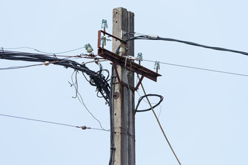 power line on a wooden post against the blue sky