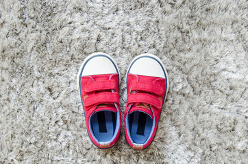 Fototapeta premium Red kid sneaker on gray mat.