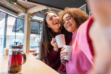 Multiracial best friends taking a selfie at the bar