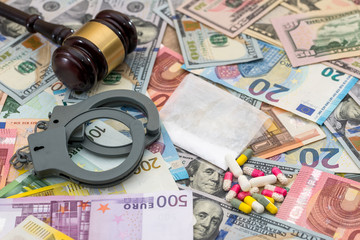 drug and substances prohibited with handcuffs on dollar and euro bills.