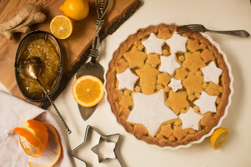 Flat lay tart with lemon and orange, ginger jam decorated with star-shaped cookies