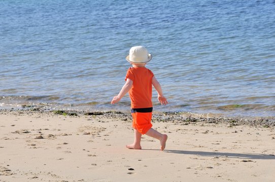 Un petit garçon court sur une plage en Bretagne