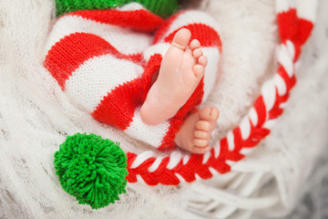 Close up picture of newborn baby feet on knitted plaid in a watt © fadzeyeva