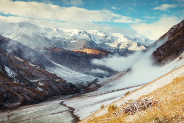 Mountain landscape of snow-capped mountains in the mist.