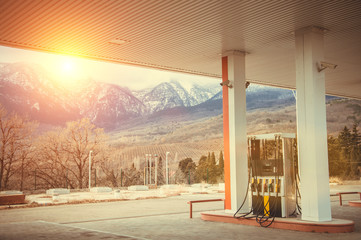 Petrol station gas station with a view of snow-capped mountains and shining sun