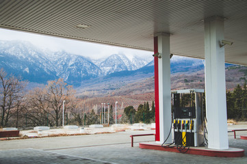 Magnificent views of the car refueling with views of the beautiful mountains with snow