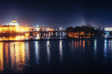 Fototapeta na wymiar Reflection of Prague caste and the Charles bridge at dusk.
