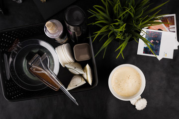 
morning cup of hot coffee on the table together with creams and oils for hair care
