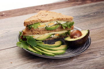 Sandwich with avocado and poached egg - healthy breakfast concep