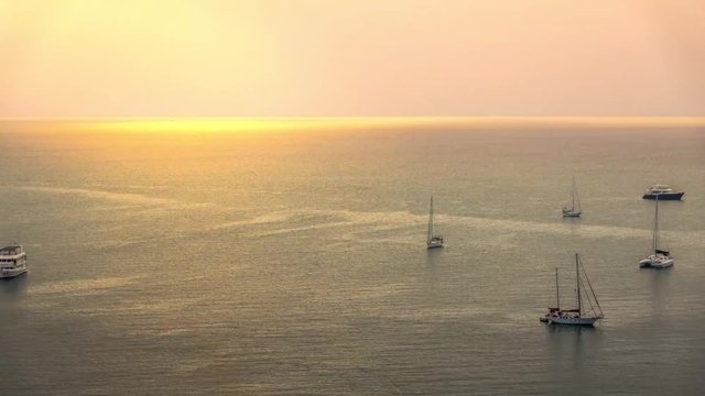 boats in the sea during a golden sunset, setting sun over the Sea, time-lapse video footage.