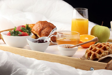 breakfast in bed with fruits and pastries on a tray -waffles, cr
