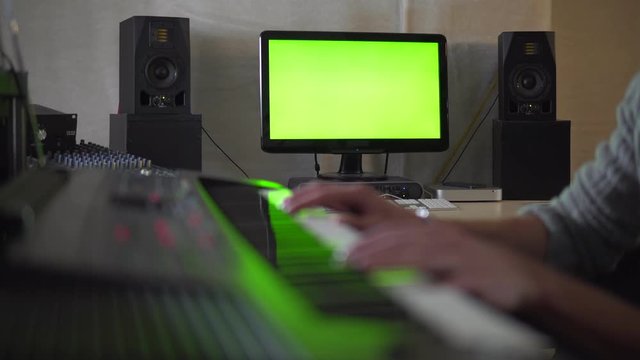 Man playing on synthesizer in Studio on green screen