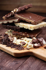 Chocolate bars on a wooden background with chocolate tower