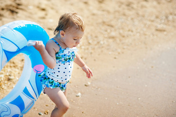 Happy little girl child bathing with inflatable circle and having fun in the sea