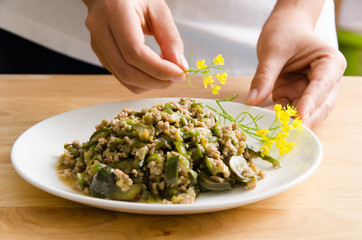 Fried green eggplant with minced pork on dish and decorative with yellow flower