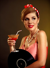Retro woman with music vinyl record. Pin up girl drink martini cocktail . Pin-up retro female style. Girl pin-up style wearing red dress