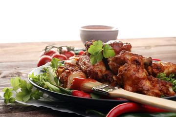 barbecue chicken wings close up on wooden tray with red spice sa