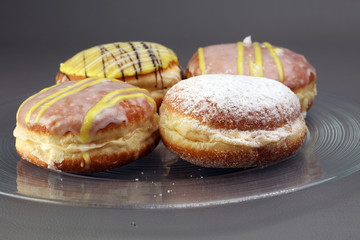 German donuts - berliner with jam and icing sugar in a tray on a
