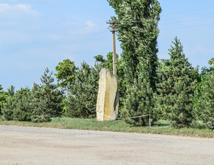 Placed vertically megalithic stone at the roadside. Decorative e