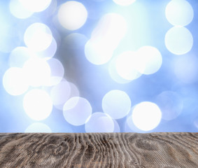 Fototapeta na wymiar Rrustic wood table in front of glitter and bright bokeh lights